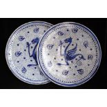 A pair of Hispano Moresque blue & white chargers decorated with a stylised dragon, 30.5cms (15.5ins)