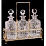 A three-division silver plated decanter carrier on ball & claw feet, with three cut glass