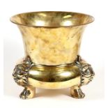 A brass planter with sun mask capped legs, on paw feet, 24cms 99.5ins) high.