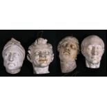 A group of four plaster masks, three marked 'Brucciani & Co.', the largest 31cms (12.25ins) high.