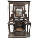 A Victorian carved oak hall stand with mirror to back, central seat with hinged base, flanked by