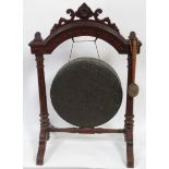 A large Victorian gong mounted in Gothic oak frame with reeded pillar supports, with striker,