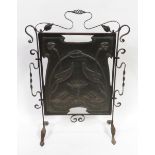 An Arts & Crafts copper and wrought iron fire screen, the centre panel embossed with sinuous Lilly