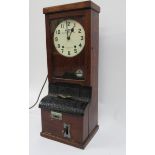 A Blick time Recorder in oak case having circular white dial and decorative cast iron panels to