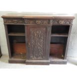 A Victorian carved oak breakfast cabinet fitted with three short frieze drawers, central door