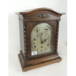 An Edwardian oak cased mantel clock, having arched silvered dial with regulator & chime/silent dials