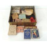 A Peak Frean biscuit tin containing early 20th Century packs of playing cards, magic tricks &