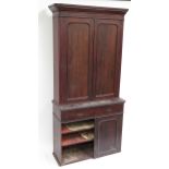 A Victorian mahogany two section cupboard, the upper part with pair of panelled doors enclosing