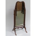 An early 20th Century walnut Queen Ann style cheval mirror having shaped top, bevelled plate &