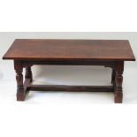 A 17th Century style oak refectory table the three plank top with cleated ends, on four turned