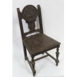 A Victorian carved oak chair with solid seat