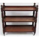 A Victorian mahogany three tier buffet with reeded supports and on original brass & ceramic castors,