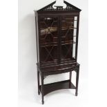 A reproduction mahogany display cabinet in Chippendale style with blind fret decoration & with
