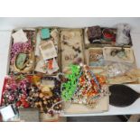 A large quantity of assorted costume jewellery including bead necklaces, earrings, compacts, hand