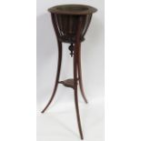 An early 20th Century mahogany jardiniere stand, the openwork top containing brass liner, with