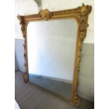 A large decorative Victorian carved gilt wood over mantel mirror, the top carved with cartouche