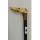 A Victorian ebonised walking cane with ivory handle carved as the head of a greyhoud & with