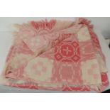 A woven Welsh wool blanket in geometric pink/white design with reverse pattern to each side,