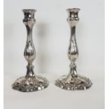 A pair of early silver plated candlesticks having reeded and moulded foliate stems and on shaped