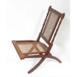 An Edwardian mahogany & woven cane folding chair