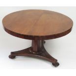 A Victorian rosewood circular tilt top breakfast table on tapering octagonal pedestal & triform