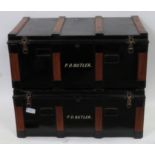 Two wood bound black painted metal travelling trunks with carrying handles to front & sides