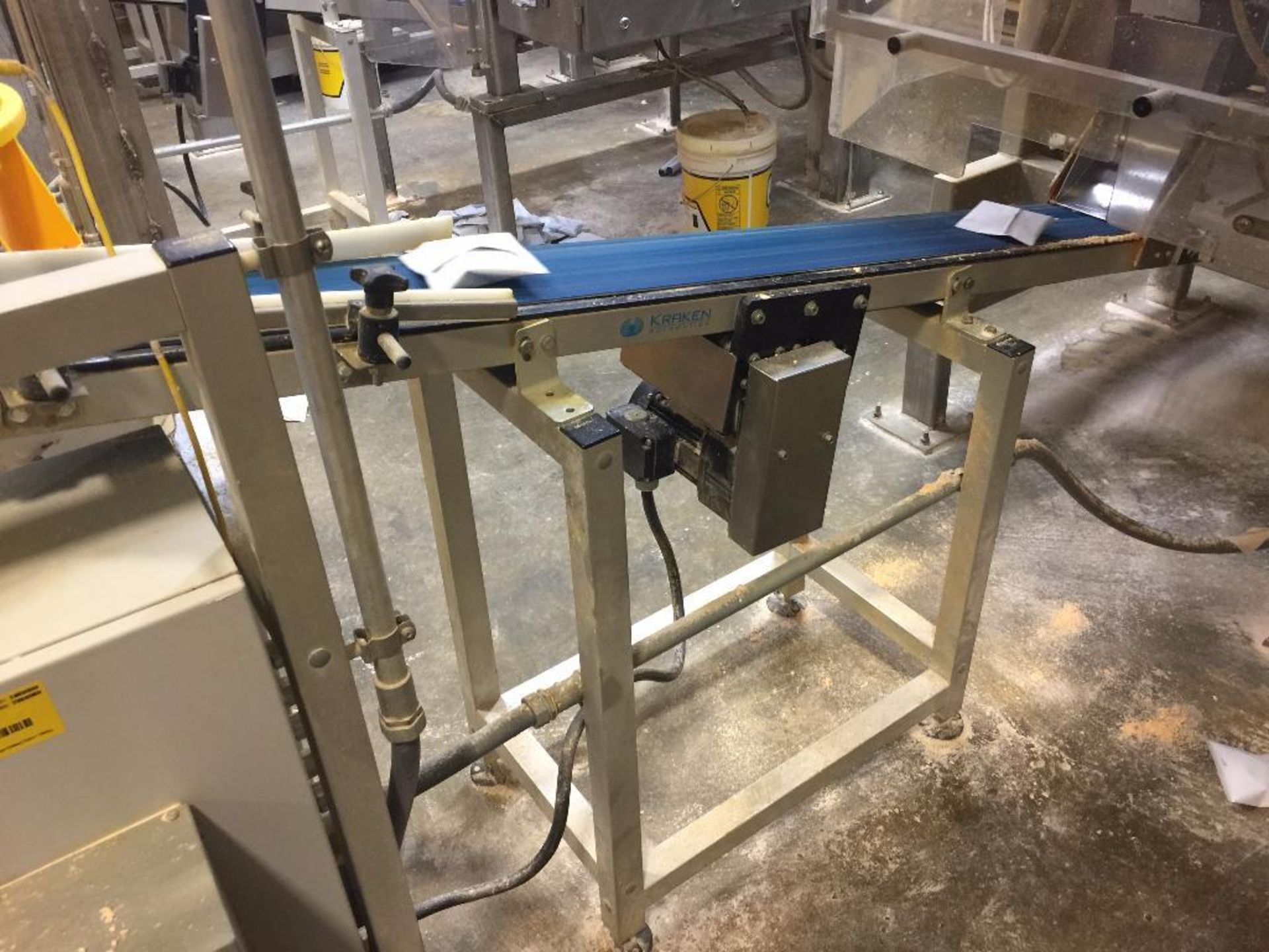 Kraken conveyor, 79 in. x 6 in. incline out of filler, blue belt, motor and drive.  **Rigging Fee: $