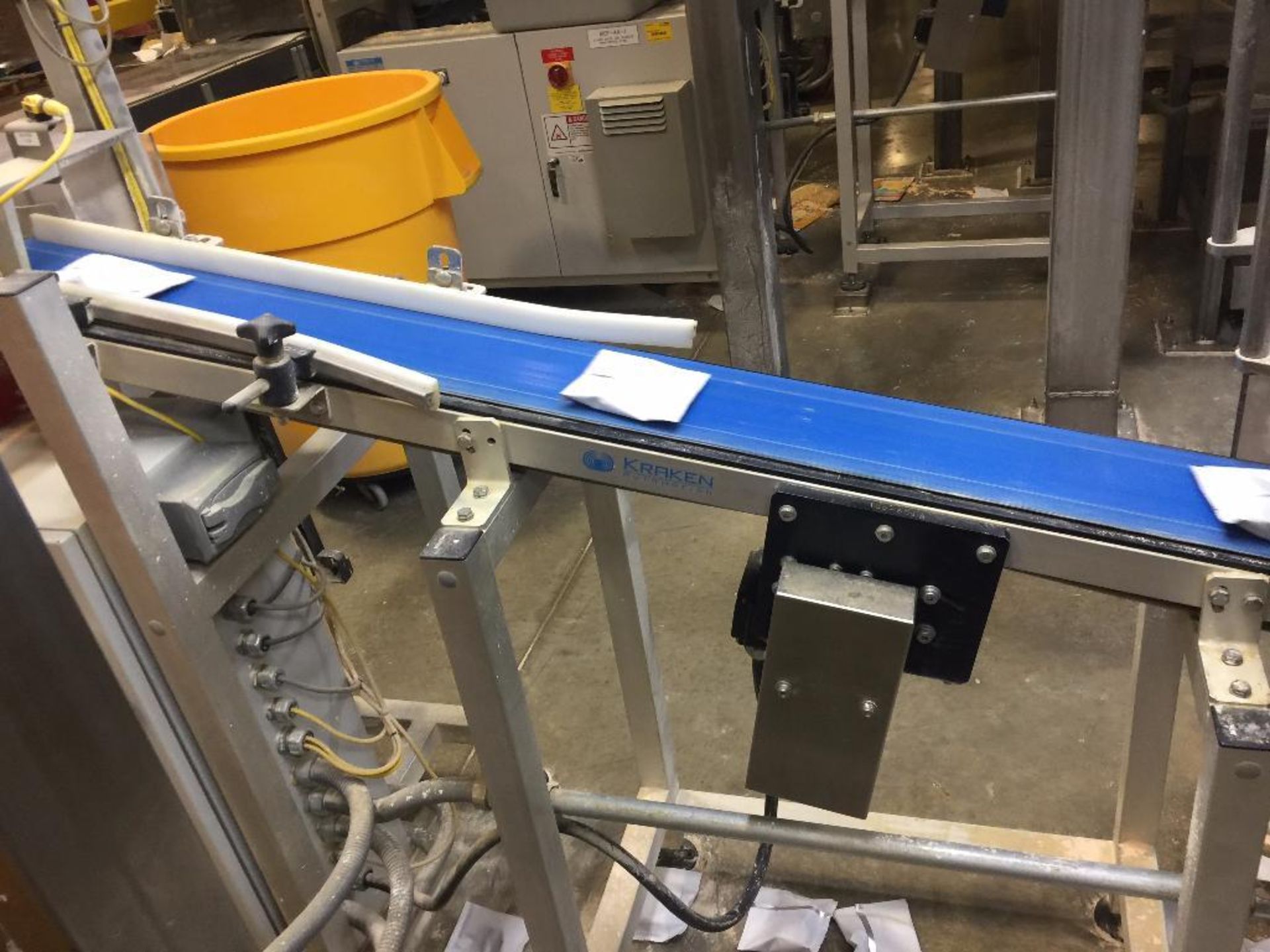 Kraken conveyor, 79 in. x 6 in. incline out of filler, blue belt, motor and drive. **Rigging Fee: $2