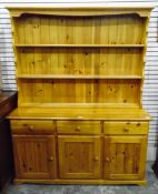 Modern pine dresser with plate rack, over a base fitted with three short drawers,