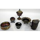 Black carnival glass pedestal bowl and cover decorated with panels of flowers,