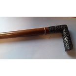 Eastern malacca walking cane with embossed silver coloured metal handle,