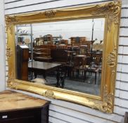 Modern gilt framed mirror, rectangular with floral decoration, the mirror with bevelled edge,