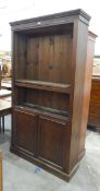 Oak bookcase fitted with open adjustable shelves over two cupboard doors, on plinth base,