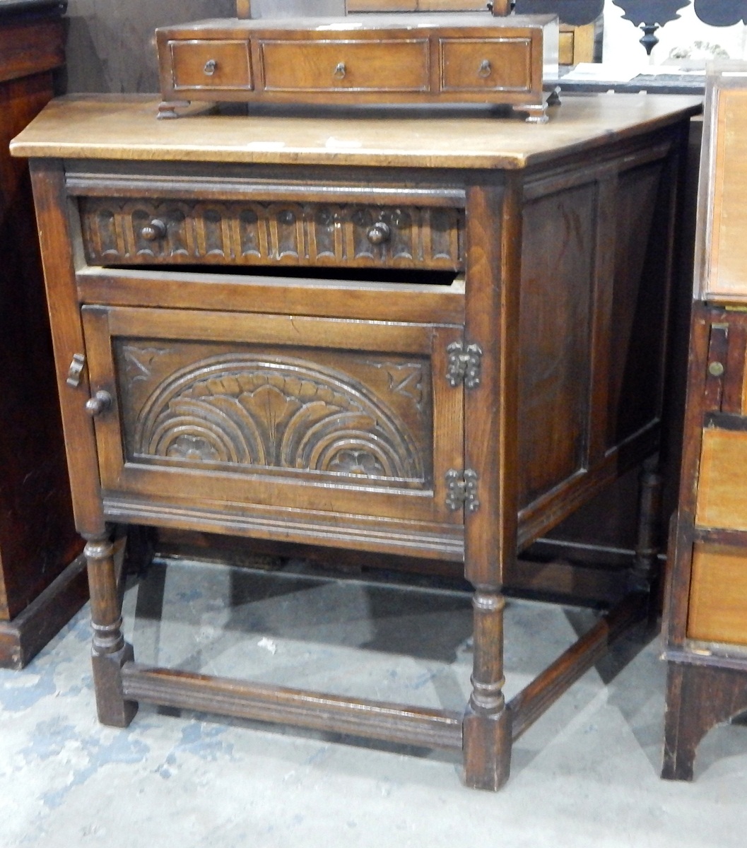 Oak side cabinet fitted with a single drawer over a cupboard, with carved decoration,