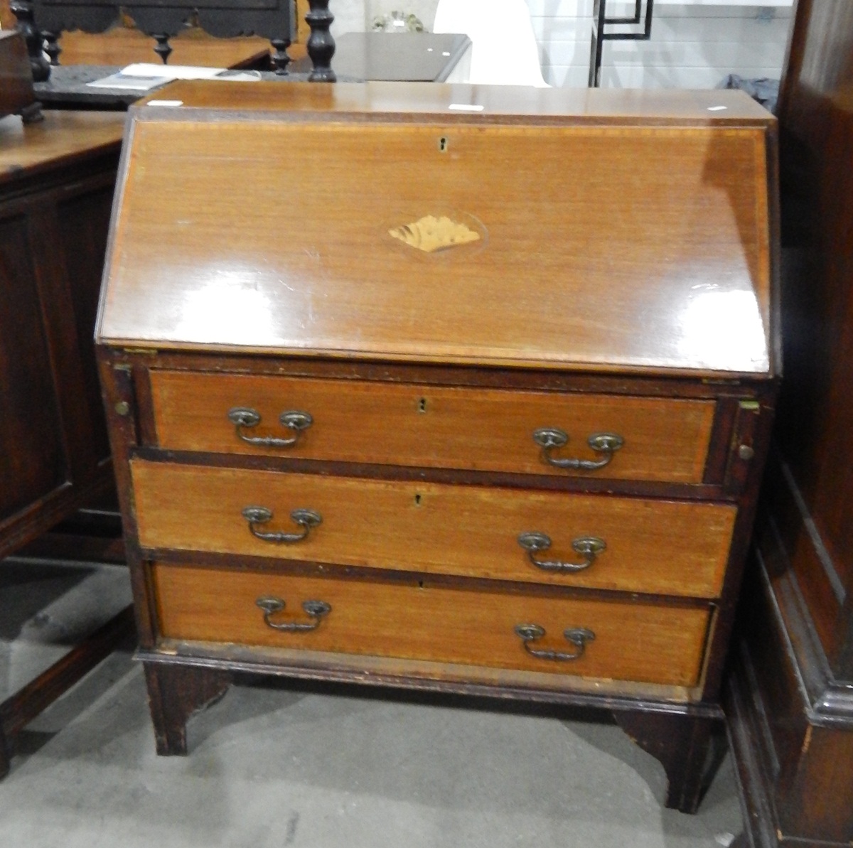 Edwardian mahogany bureau, the fall front with inlaid shell decoration over three long drawers,
