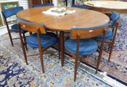 Mid 20th century G-Plan extending dining table of oval form with a set of six dining chairs