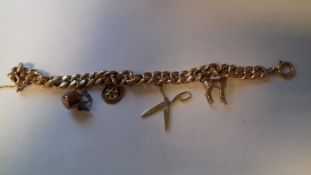 Gold (possibly 18ct) charm bracelet, curb link pattern hung with several charms,