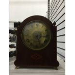 Early 20th century inlaid and stained wood bucket-style mantel clock having broken arch top with