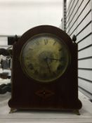 Early 20th century inlaid and stained wood bucket-style mantel clock having broken arch top with