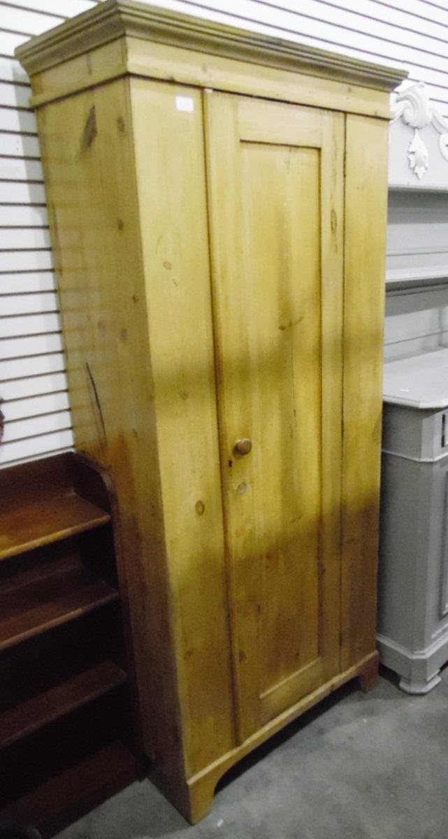 Pine single door wardrobe on bracket feet,