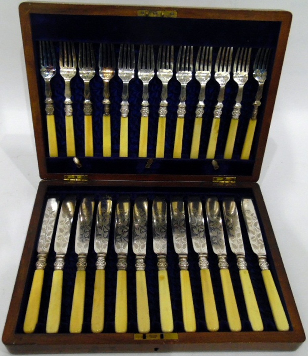 Set of 12 cream handled fish knives and forks with foliate engraved decoration,
