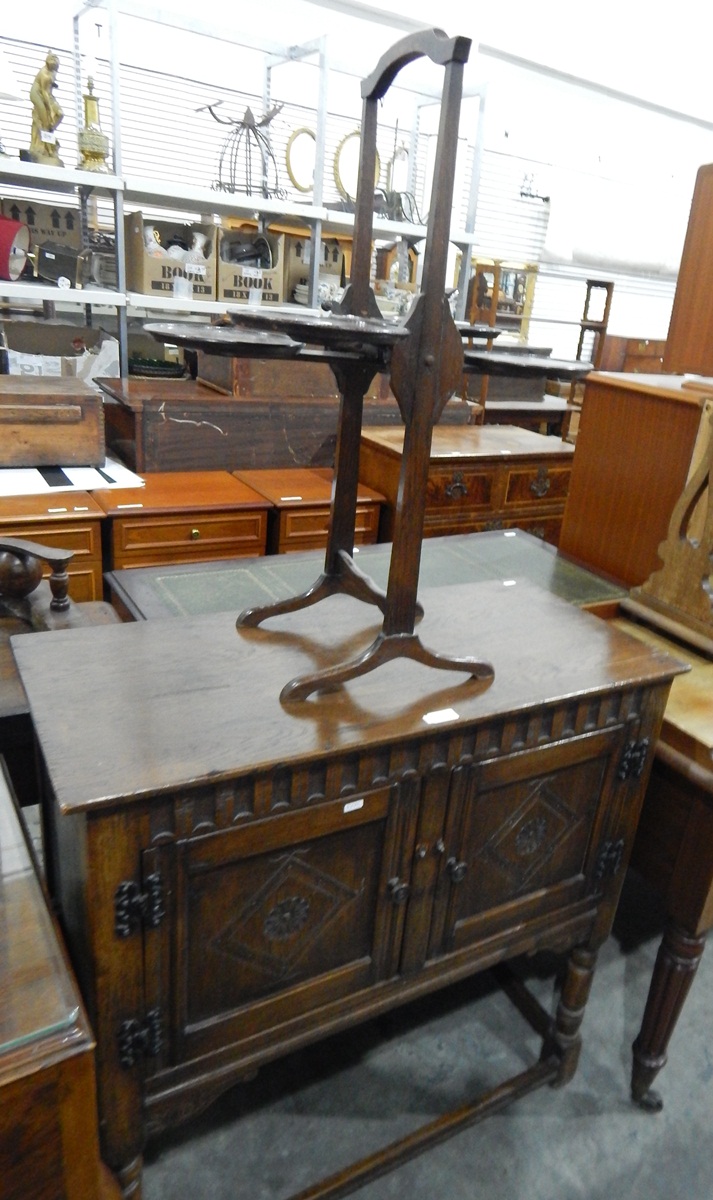 Oak side cupboard of rectangular form, fitted with two doors over turned supports and stretchers,