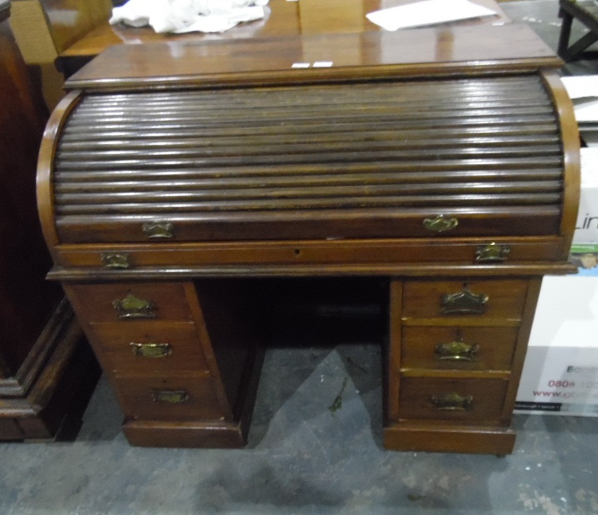 Walnut cylinder pedestal desk, the tambour cover revealing a fitted interior,