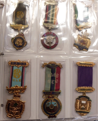 Collection of Masonic medals within a folder with plastic pockets