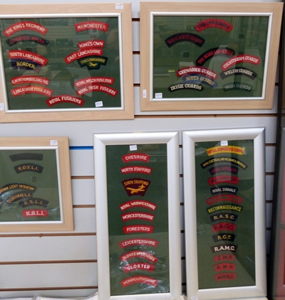 Cloth shoulder titles of British regiments contained within five frames (5)