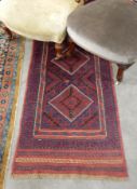 A Persian wool runner in red with blue decoration,