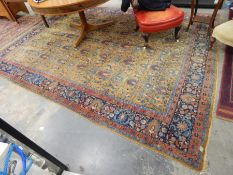 A Persian rug yellow ground floral design to centre, with red and blue borders,
