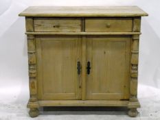 Pine side cupboard, the moulded edge top above two short drawers,