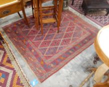 A Persian wool rug, red ground with medallion deign and geometric borders,