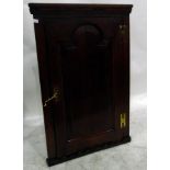 Georgian oak corner cupboard, the arched fielded panel door enclosing shelves,